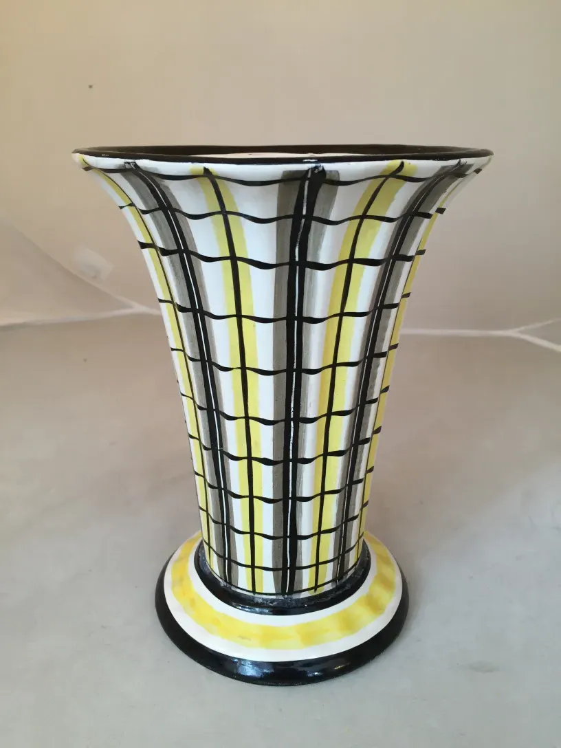Vaso antico in ceramica decorato con linee gialle e nere.
