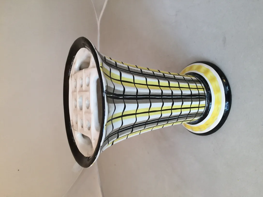 Vaso in ceramica antica con design a strisce gialle e nere.