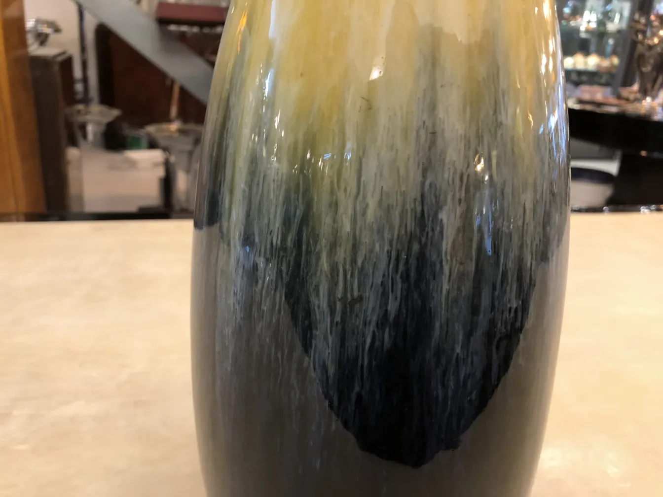 Vase en céramique ancienne avec un design dégradé en jaune et noir.