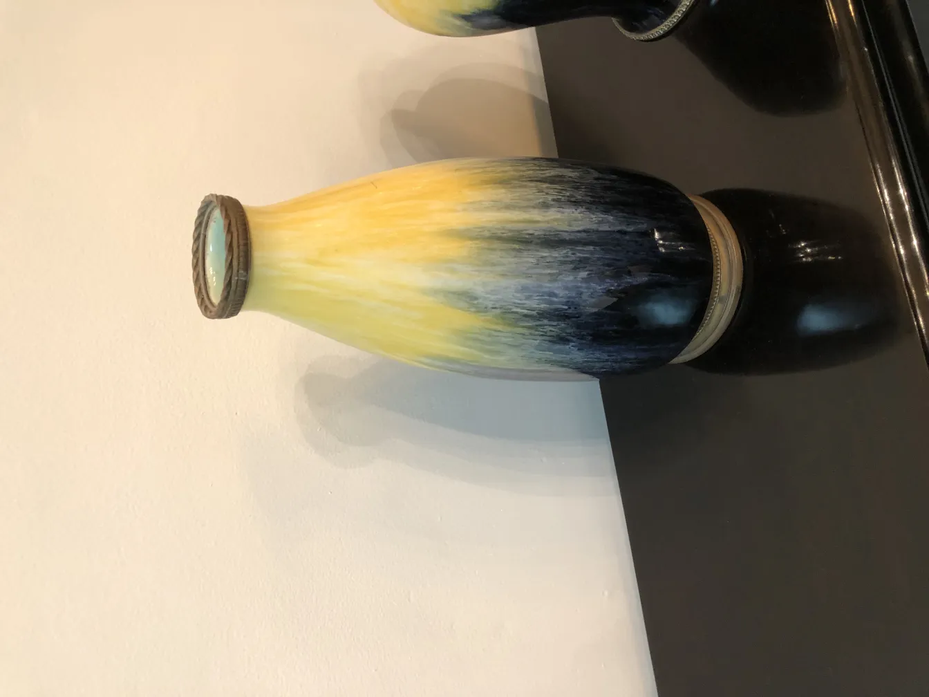 Vase en céramique ancien aux couleurs jaune et noir avec des détails décoratifs.