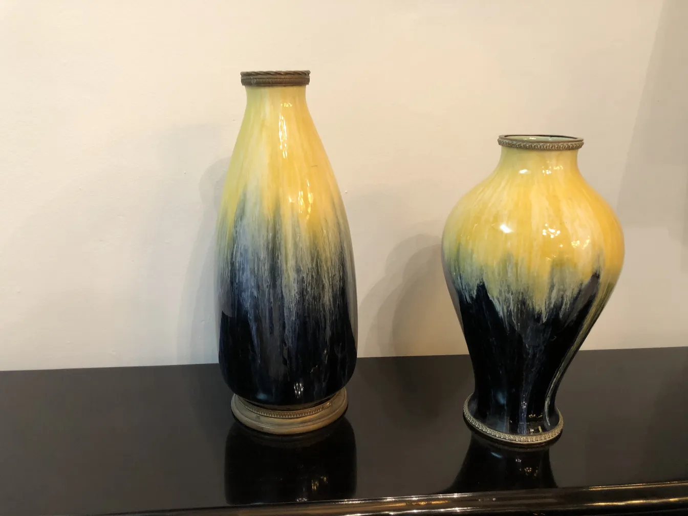 Two antique ceramic vases in yellow and black hues.