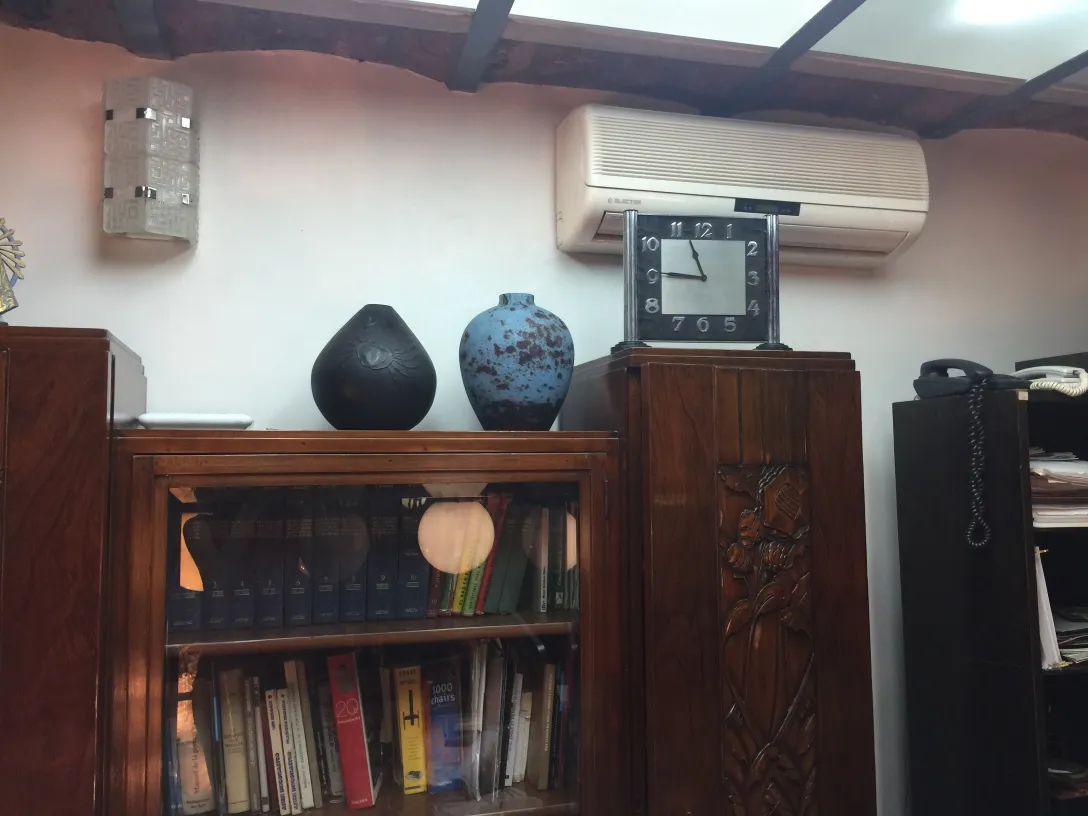 Élégante céramique ancienne dans des tons sombres et bleus sur une étagère.