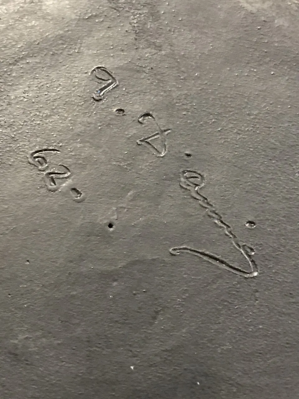 Inscription visible sur une ancienne céramique avec des détails uniques.