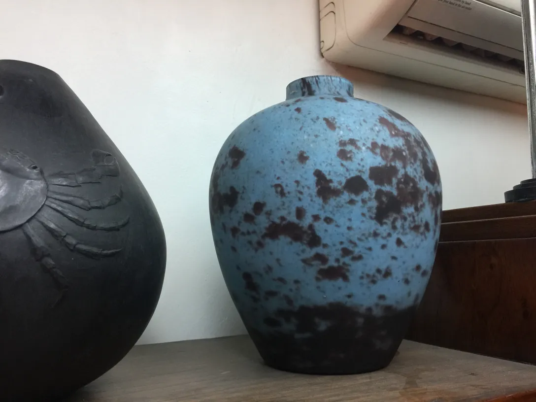 Dekorative blaue Keramik mit dunklen Flecken in antikem Umfeld