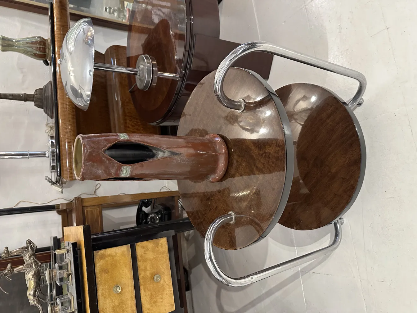 Antique ceramic vase with an excentric design in a retro furniture setting.