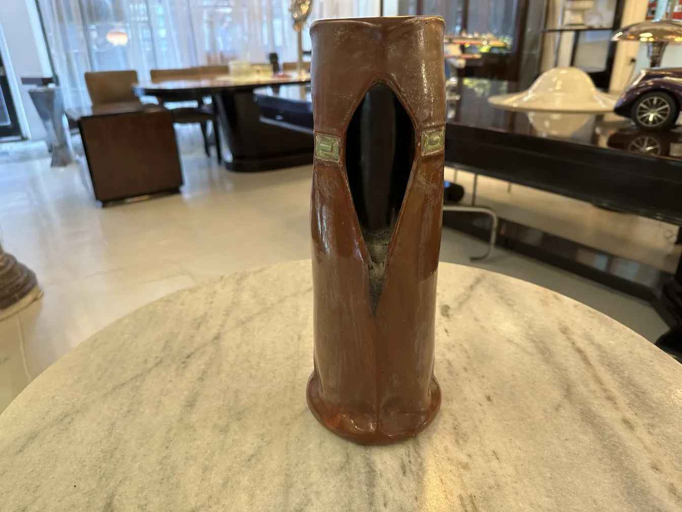 Antike Keramikvase mit einzigartigem Design in Terrakottafarben, modernem Hintergrund.