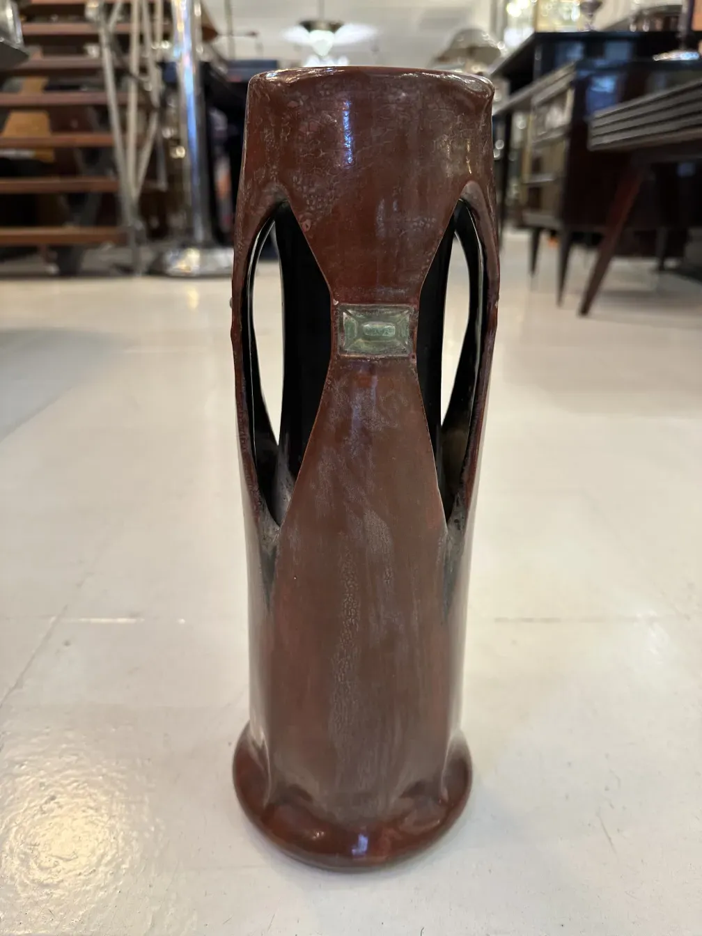 Antiga peça de cerâmica com design único de Julius Dressler, fundo neutro.