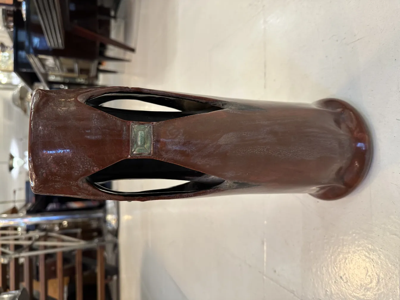 Brown antique ceramic vase with contemporary design and unique details, subtle environment.