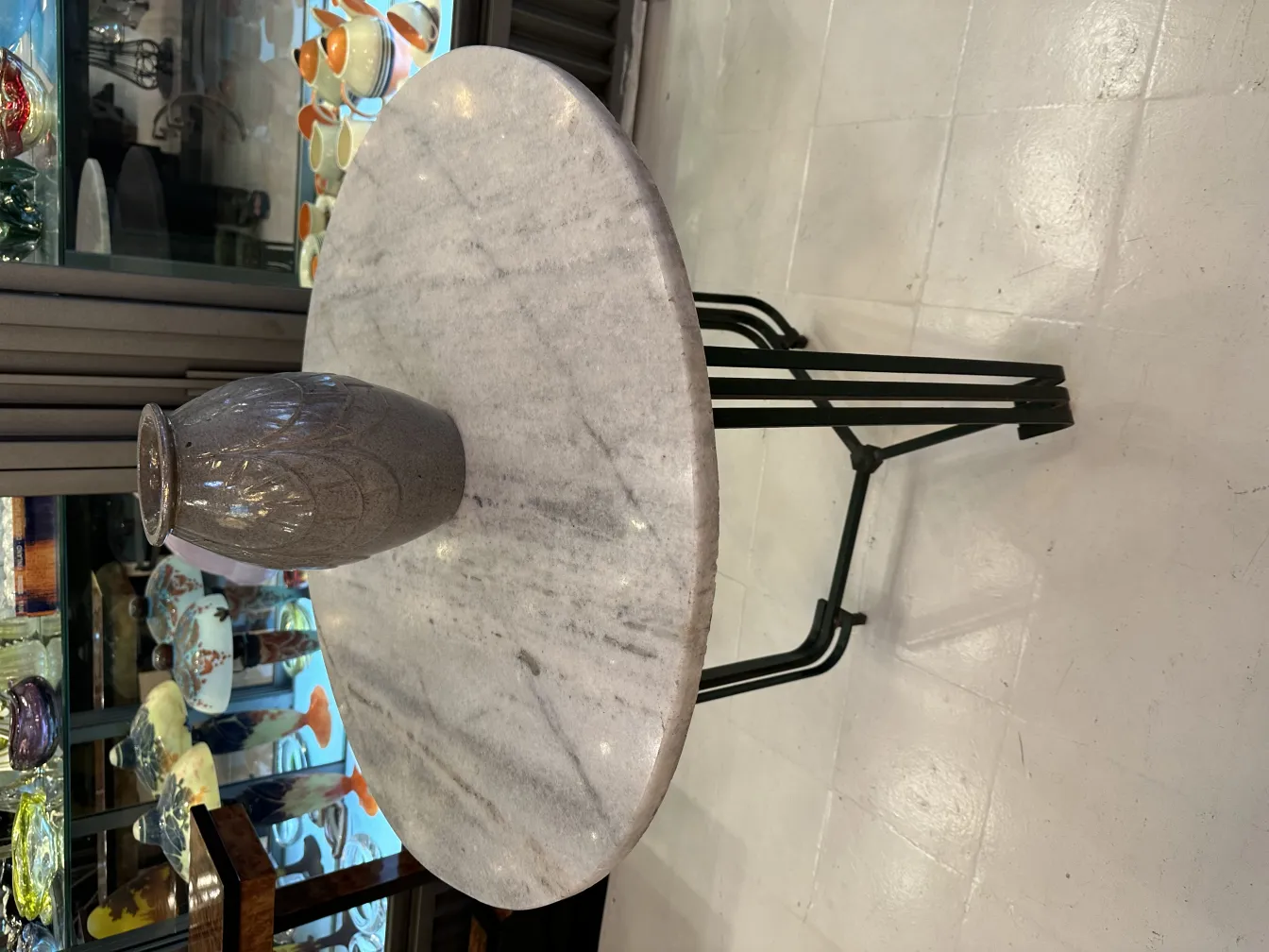 Antique decorative ceramic vase on a modern table, with background of antiques.