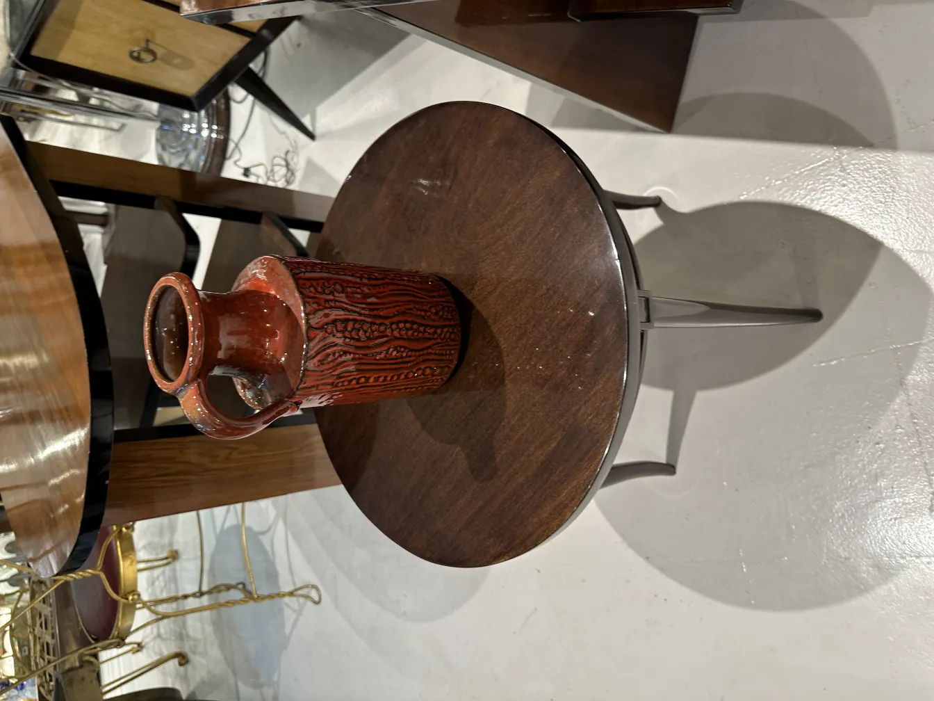 Jarra de cerâmica antiga com design texturizado sobre uma mesa