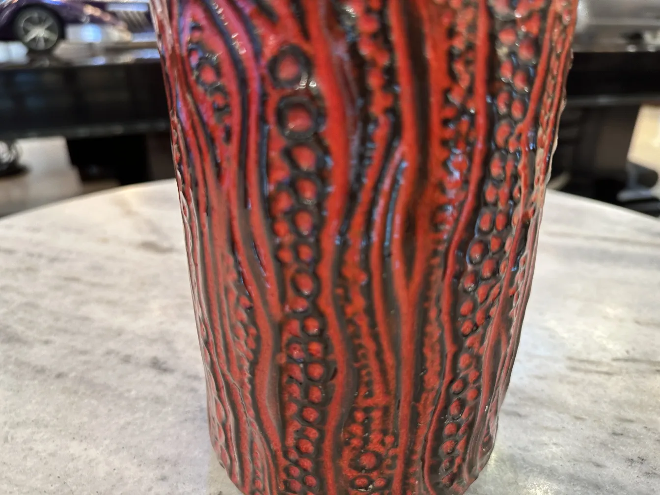 Antica ceramica rossa con texture in un ambiente elegante.