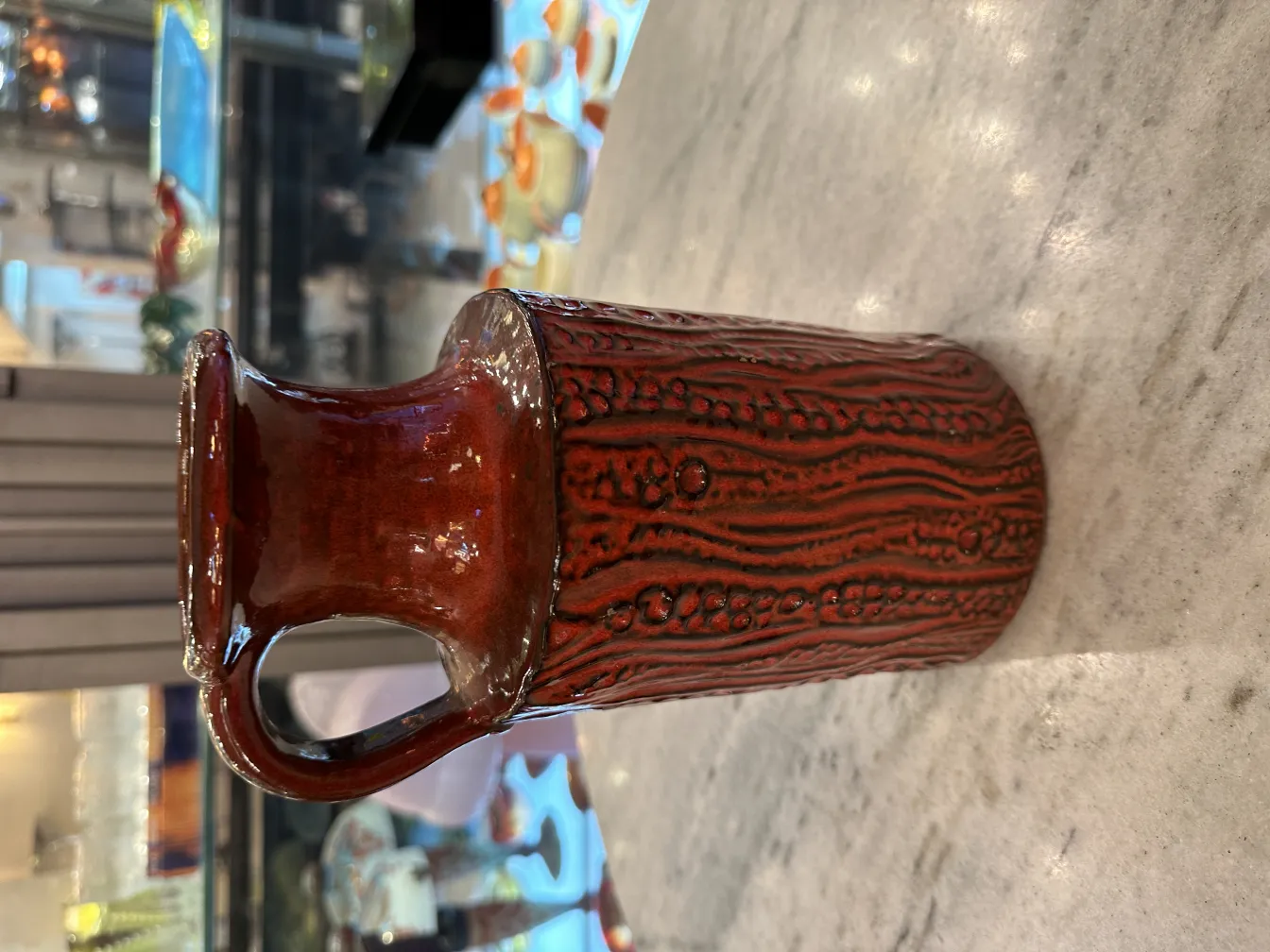 Antique red ceramic jug with detailed texture