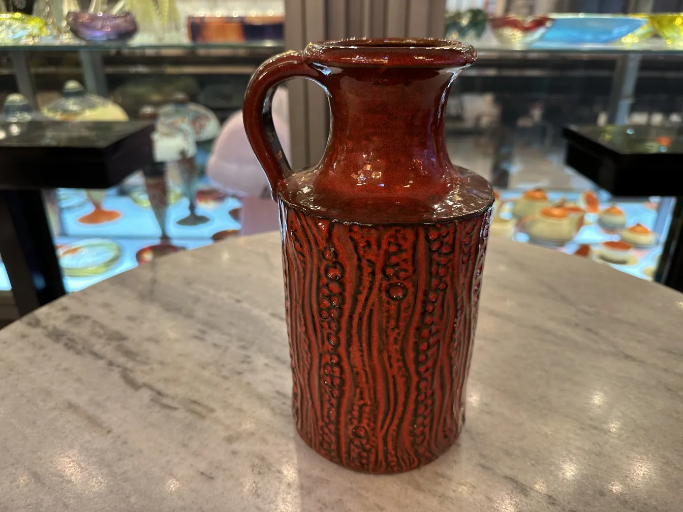 antique ceramic jug with rough pattern in red