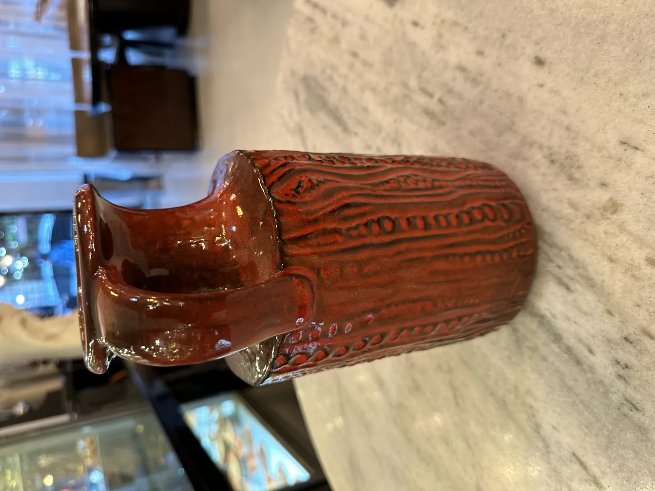 Vaso de cerámica antigo com design entalhado em tons marrons.