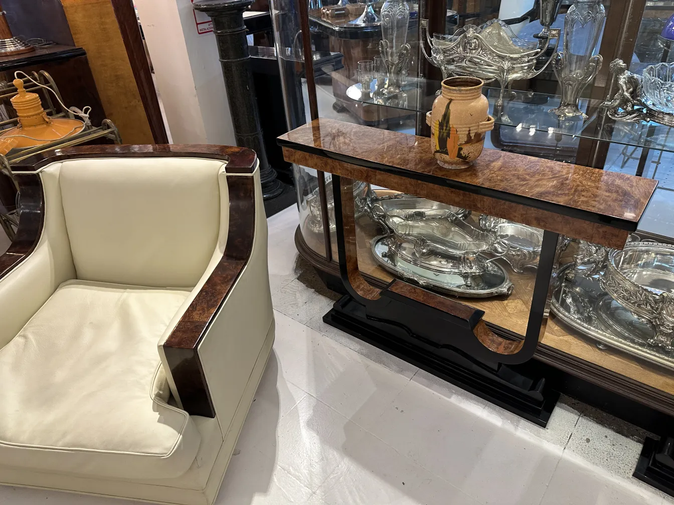 Antike dekorative Keramik mit kunsthandwerklichem Design, in einer Vitrine neben klassischem Mobiliar ausgestellt.