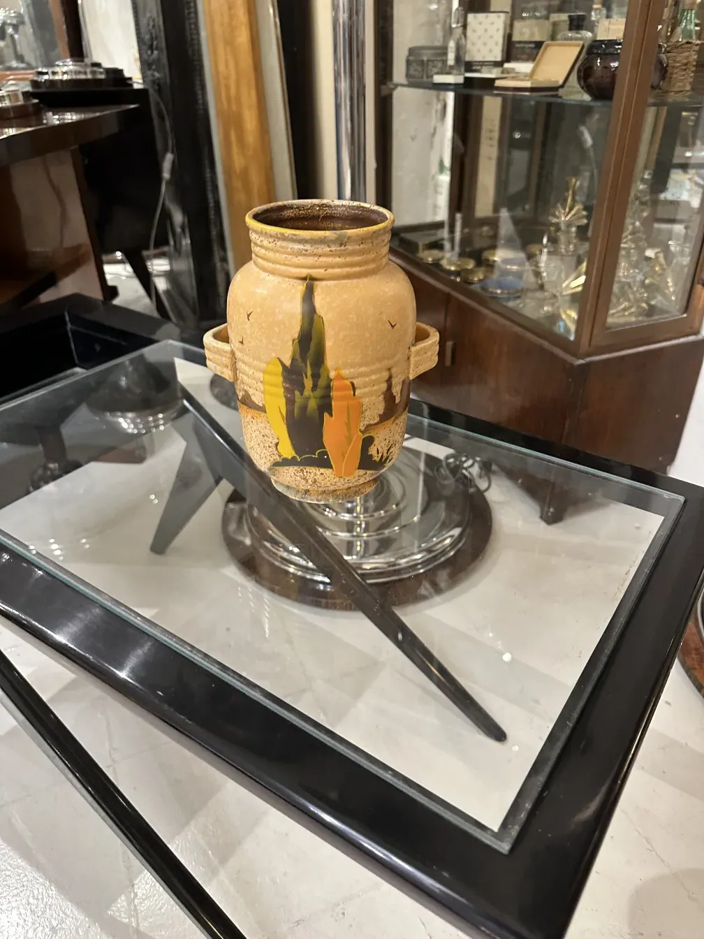 Vaso in ceramica antica con design colorato, che presenta elementi naturali.