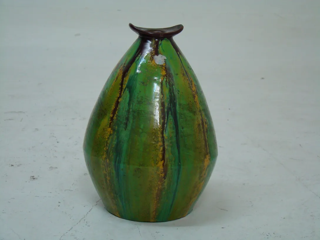 Jarrón de cerámica antigua en tonos verdes y dorados con patrones decorativos