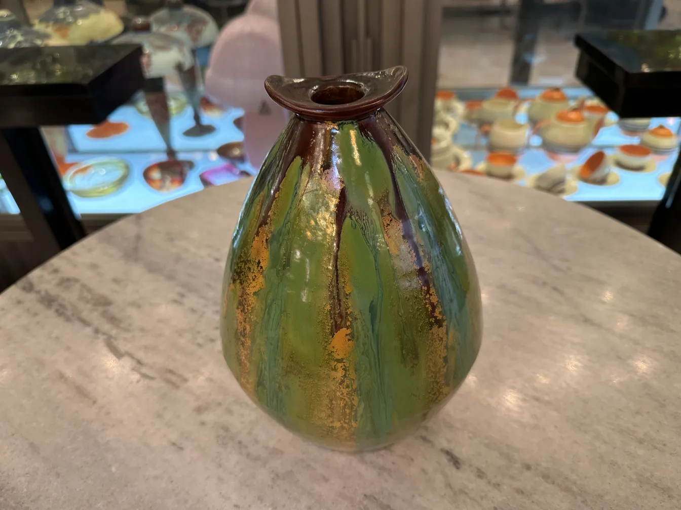 緑と金の色合いの古代のカラフルな陶器の花瓶。