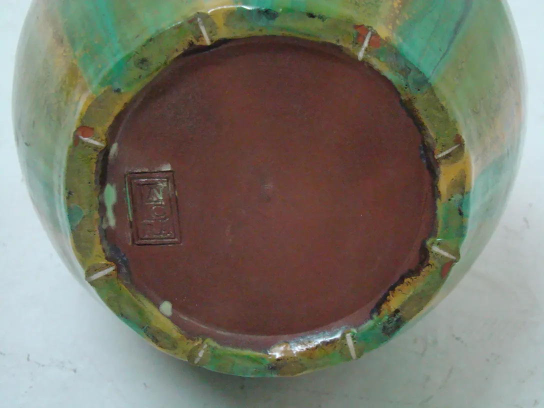 Vista della base di una ceramica antica colorata con dettagli unici.