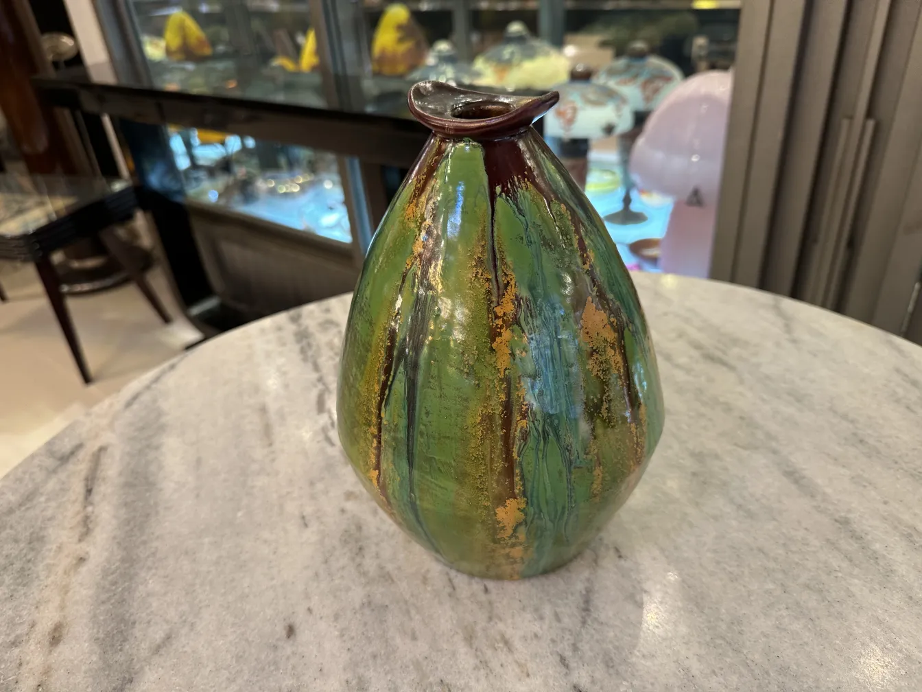 Antique ceramic vase with green and golden shades.