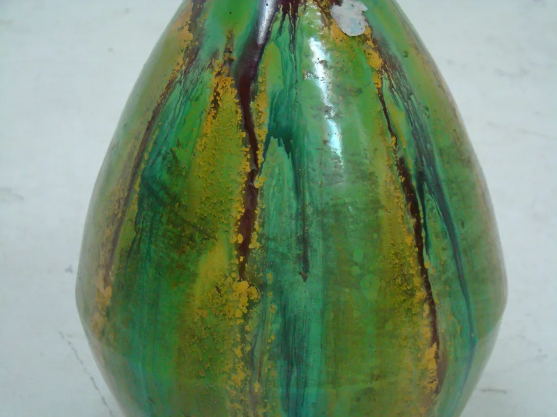 Close-up view of antique green ceramic with striking design