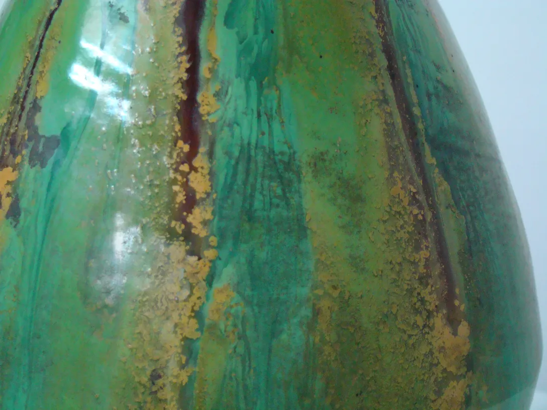 Antique green ceramic vase with irregular texture, golden accents.