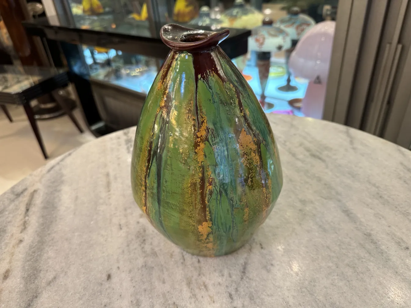 金色のディテールのある緑の陶器の花瓶、ビンテージの雰囲気。