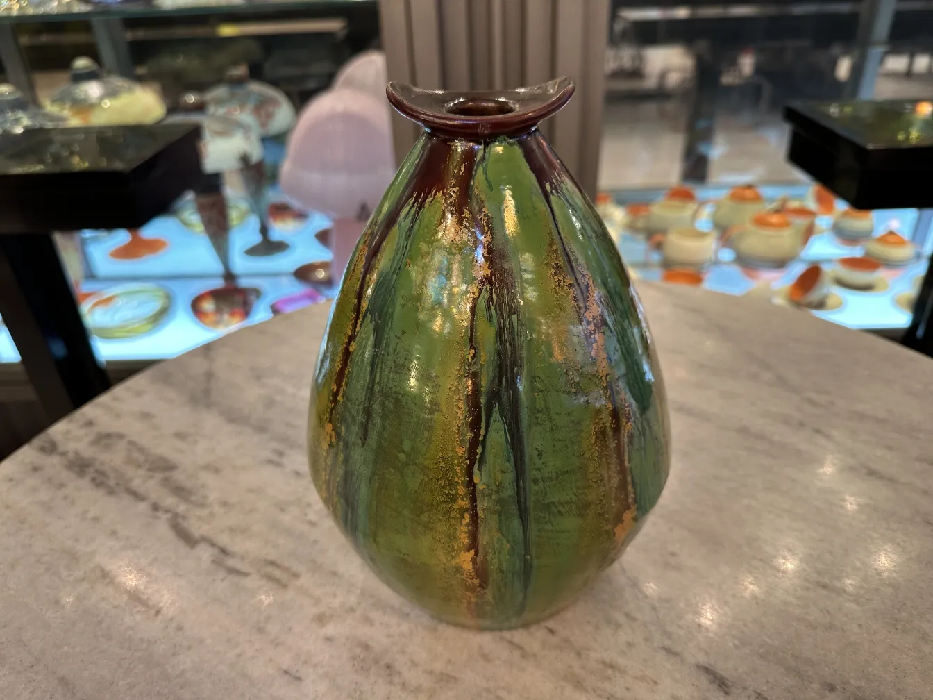 Vase en céramique ancienne vert avec des détails dorés.