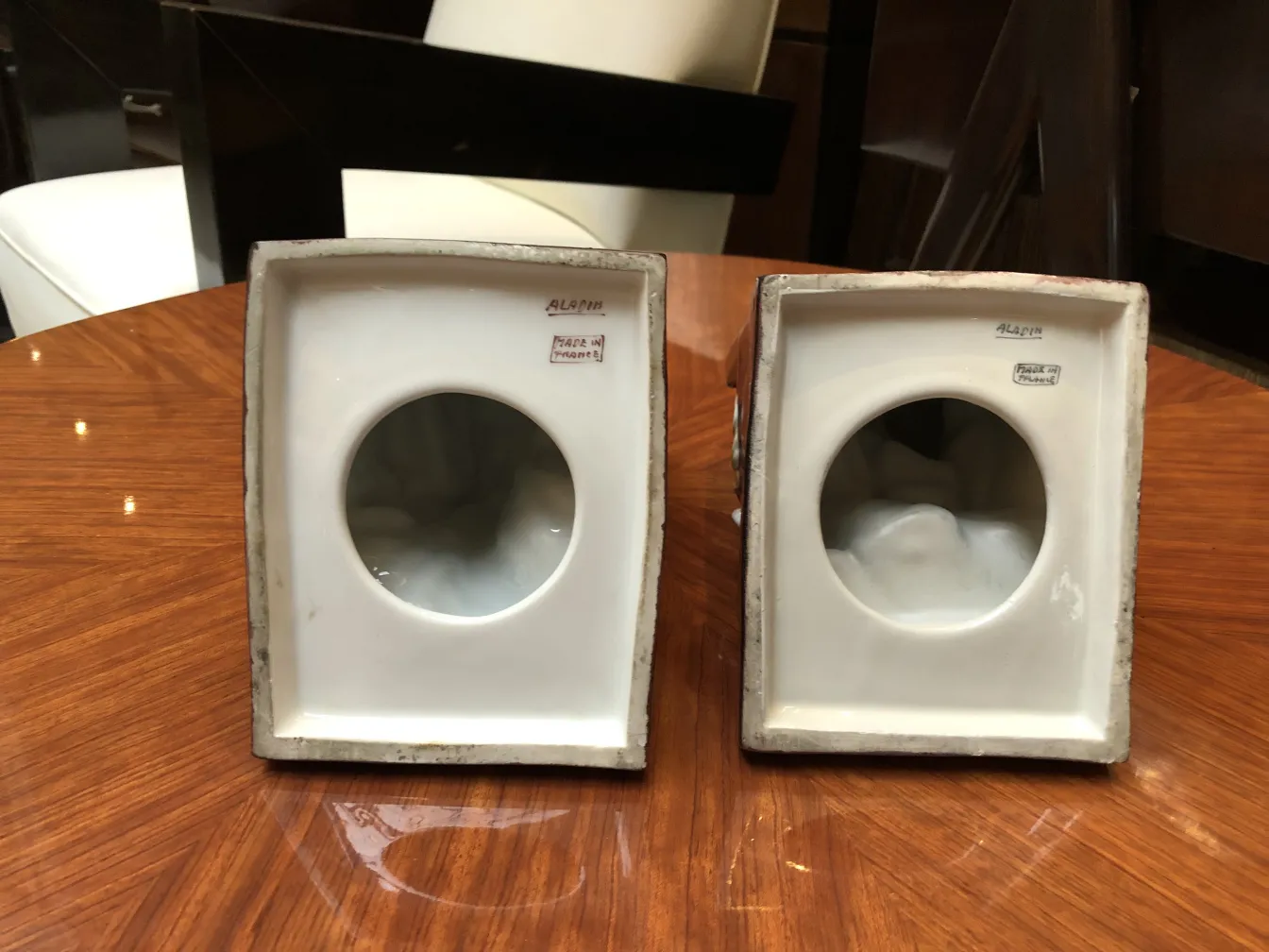 Two pieces of antique ceramic, rectangular shapes with circular openings, in an elegant setting.