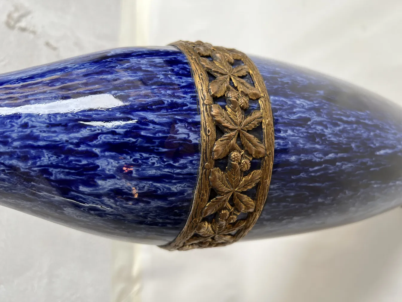 Cerámica antigua azul con detalles dorados decorativos.