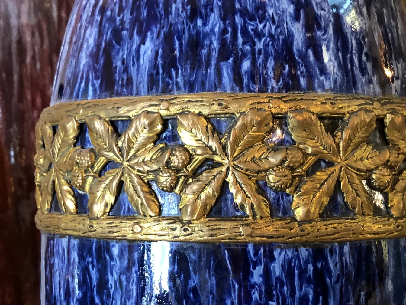 Cerámica antigua decorada con hojas doradas y azuladas