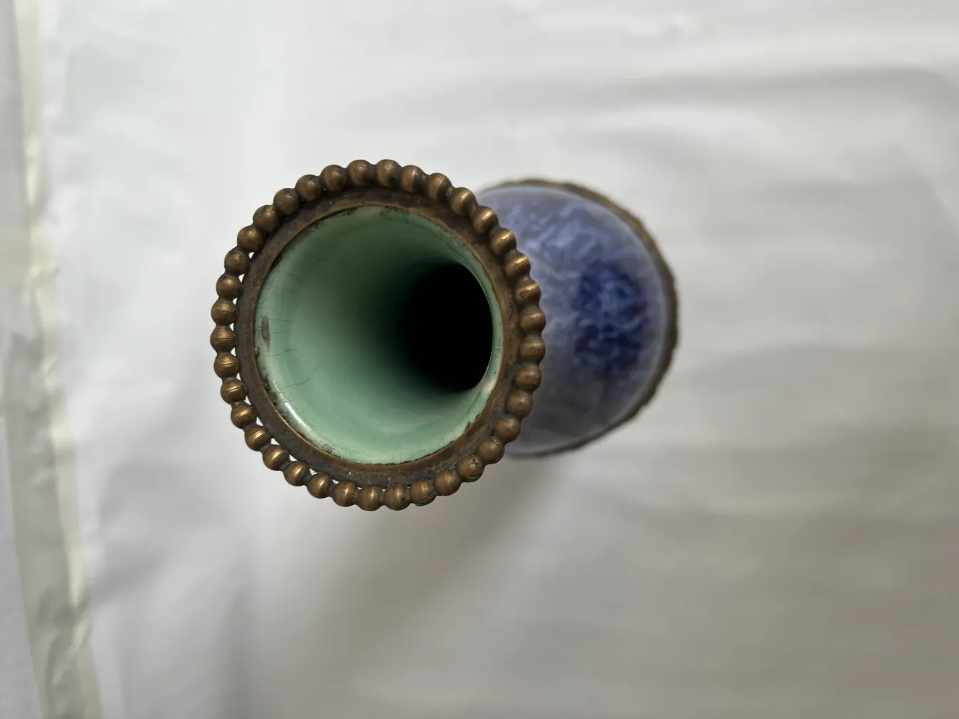 Detail of an antique ceramic vase with a golden rim