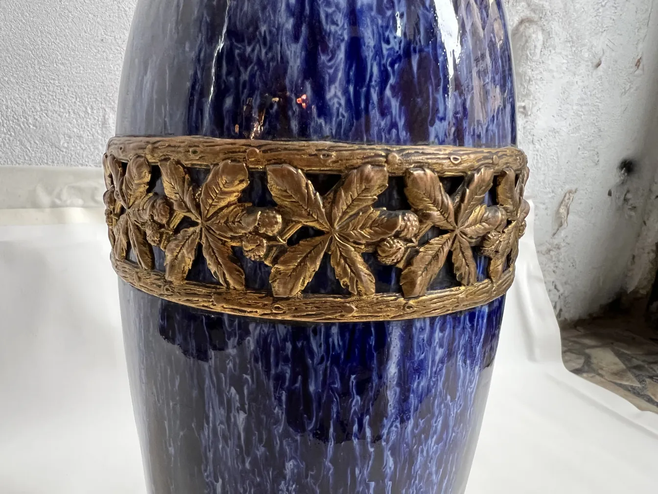 Jarrón antiguo de cerámica con acabado azul y detalles dorados