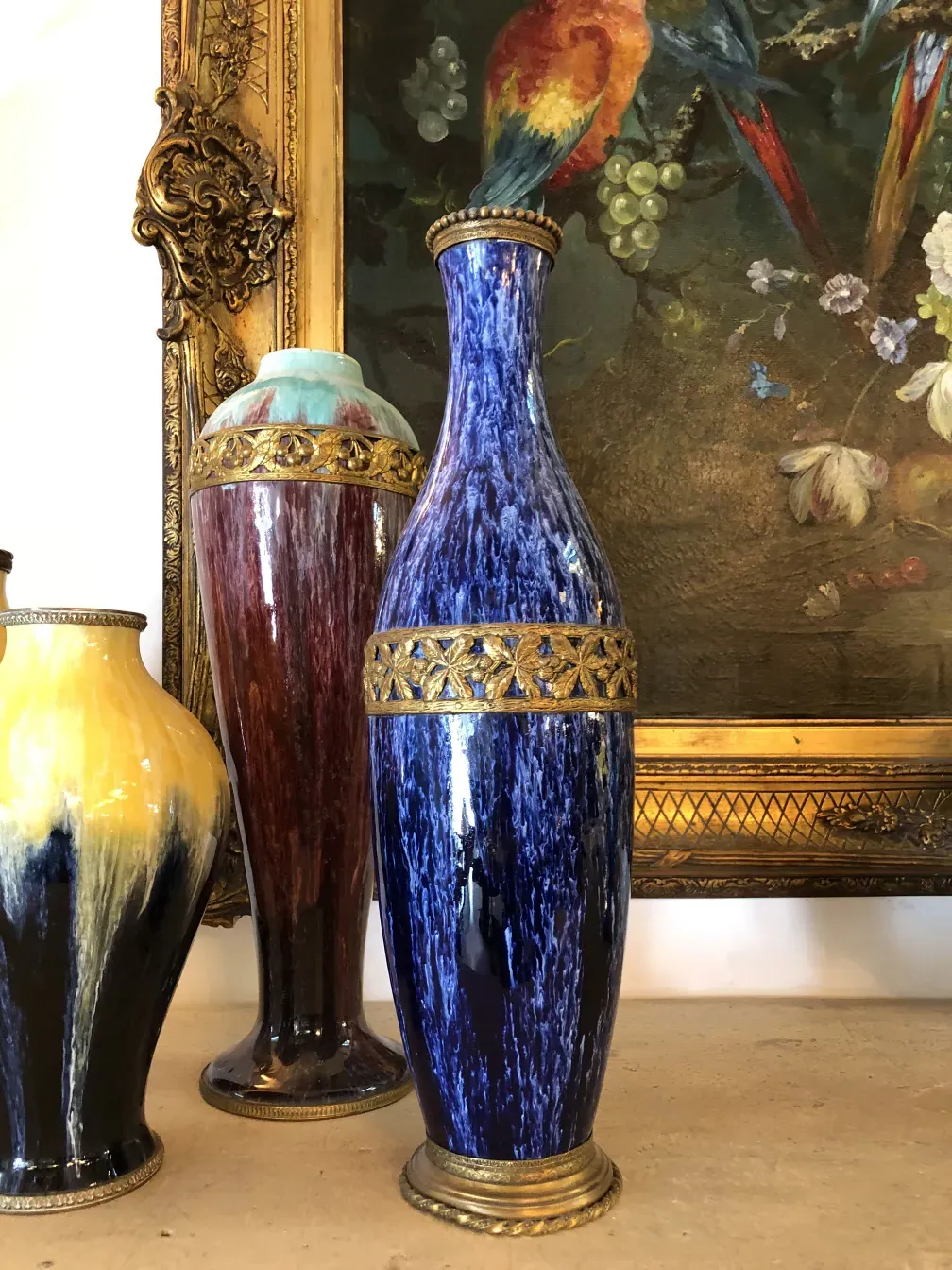 Three antique ceramic vases with vibrant colors and golden details, classic decorative background
