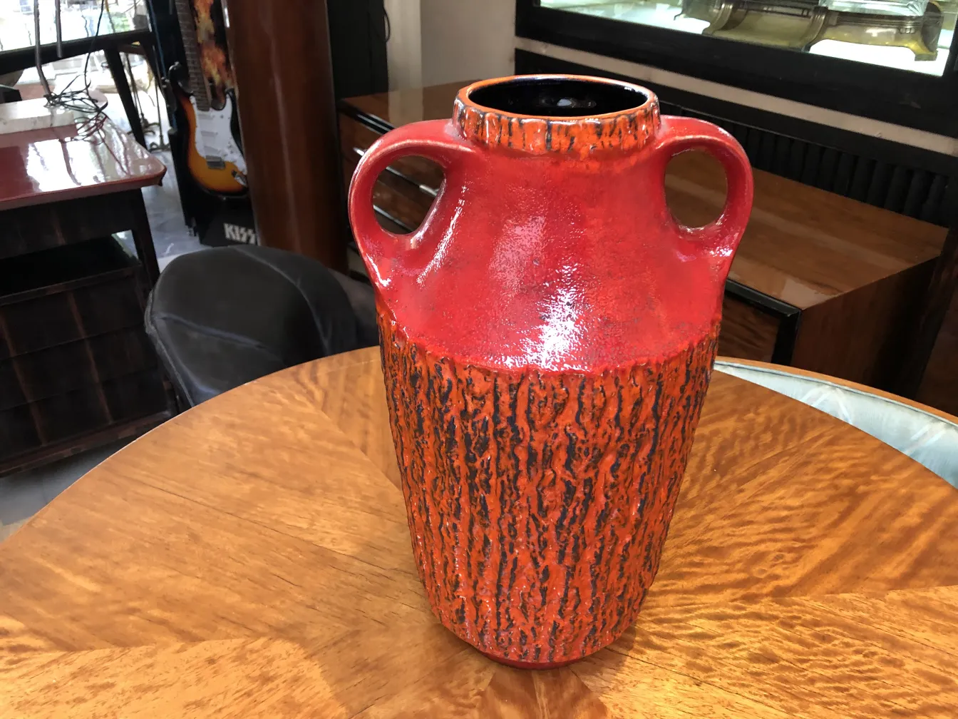 Antike rote Keramikvase mit rauer Textur und Griffen.