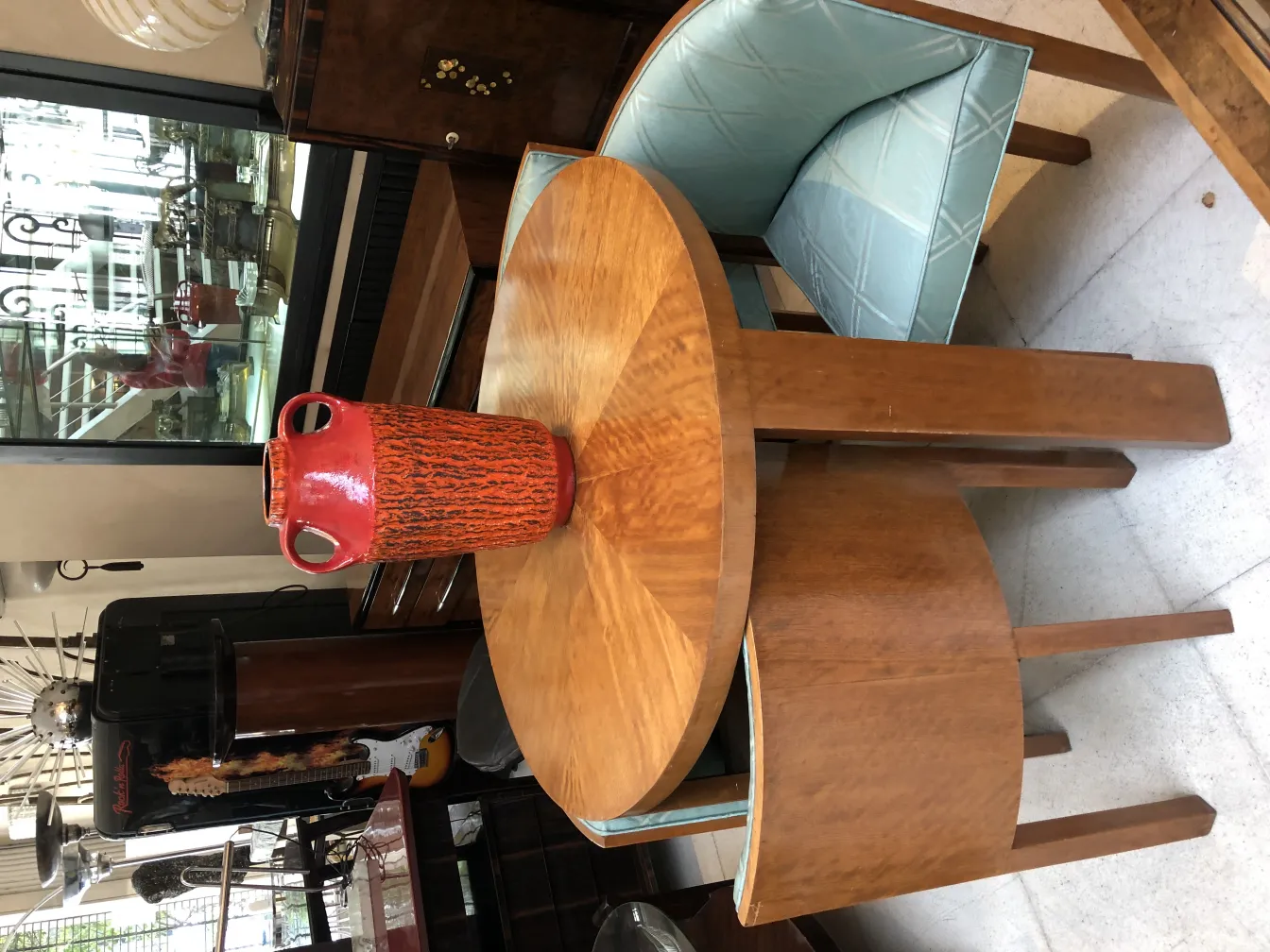 Vase en céramique ancienne rouge et noir, style unique dans un cadre chaleureux.