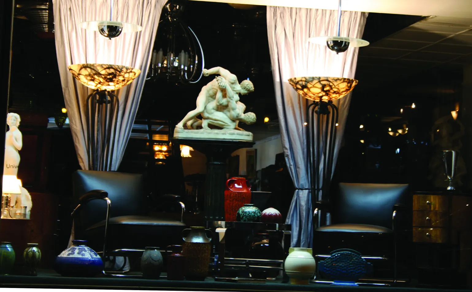 Antique ceramic pieces in various colors and decorative shapes, displayed in an elegant setting.