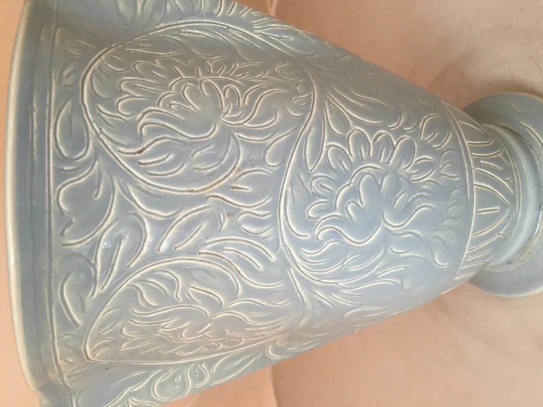 Cerâmica antiga com design floral intricado em relevo, elegante e decorativa.