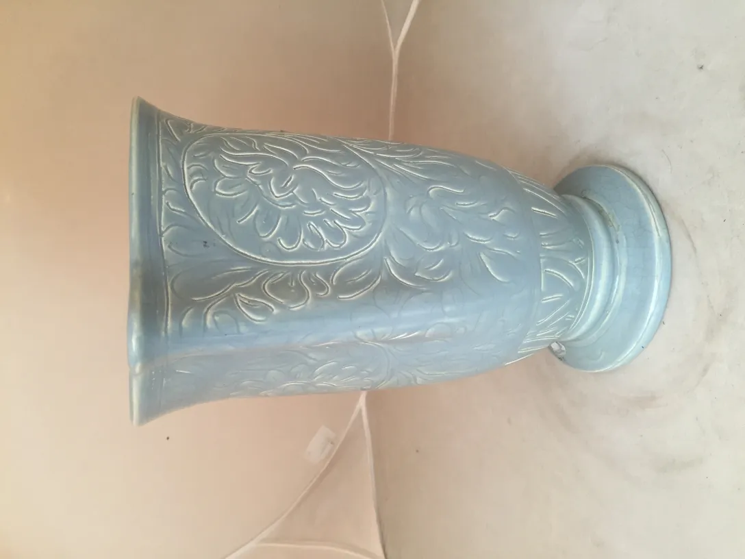 Ancienne céramique bleu clair avec motifs décoratifs.