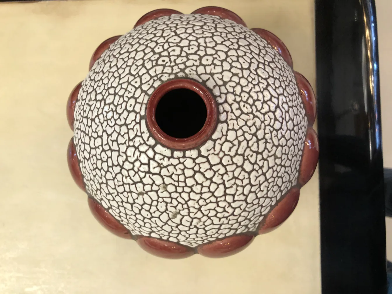 vista dall'alto di una ceramica antica st. clement con motivi in rilievo, colori terracotta e bianco