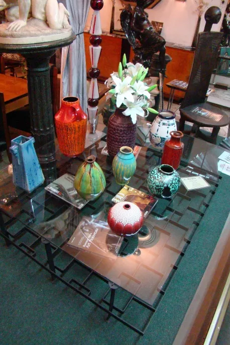 Various colored antique ceramic vases displayed in showcase