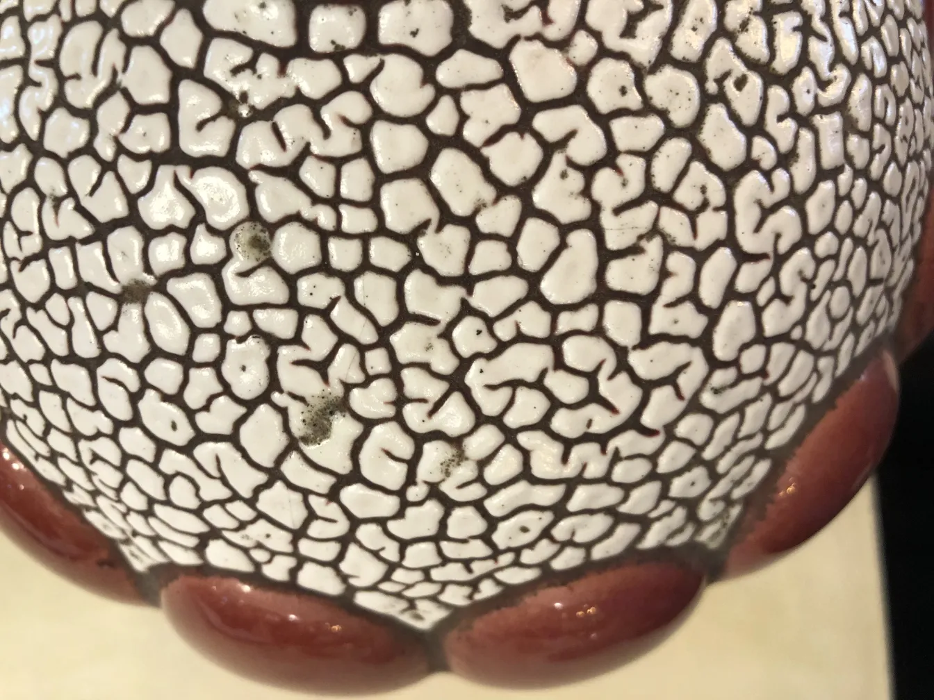 dettaglio di una ceramica antica brillante con texture e bordo rosso