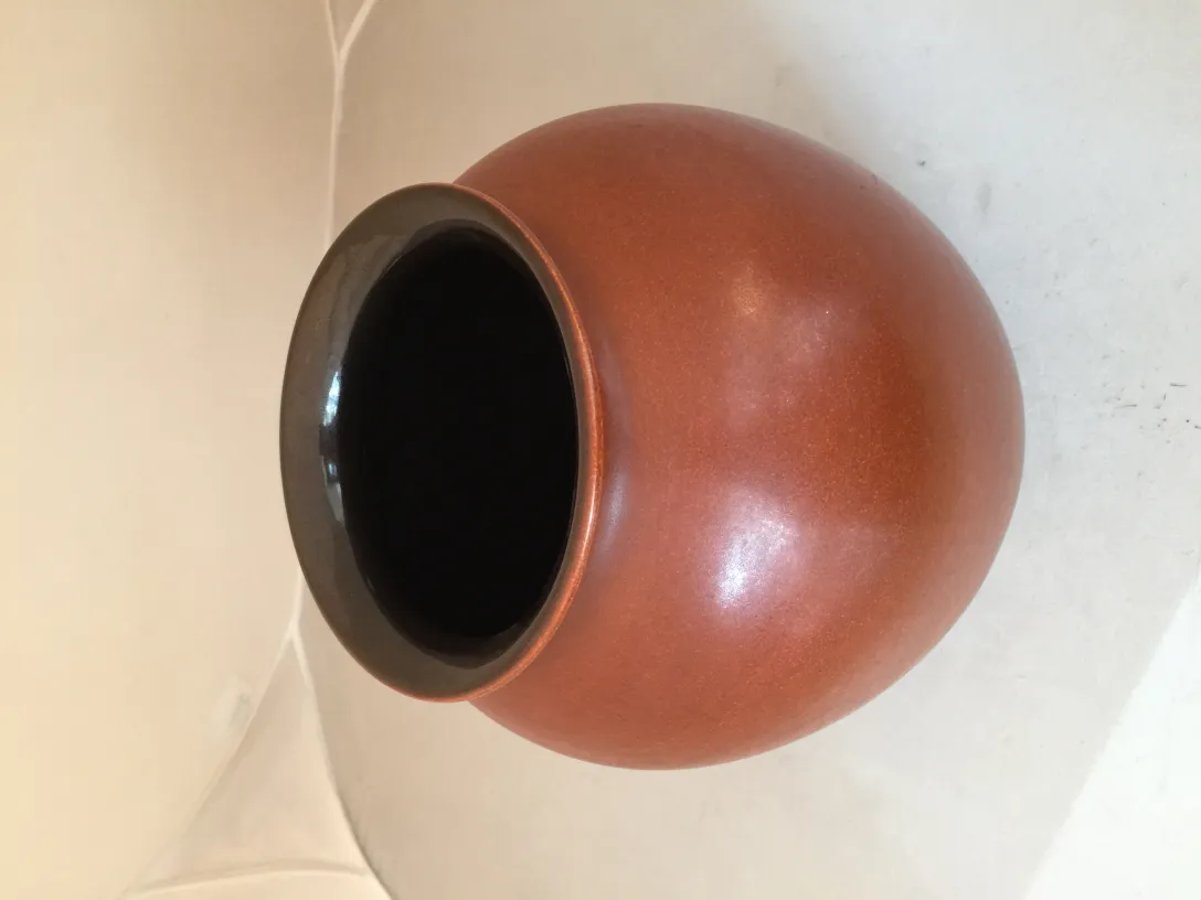 Vase en céramique ancienne avec bord noir, fond clair