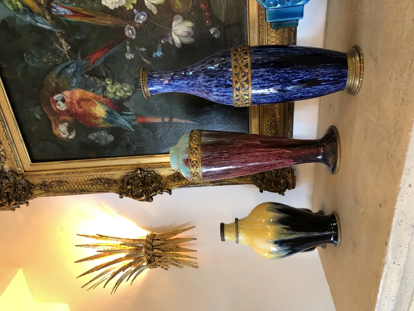 Three antique ceramic vases in vibrant colors within a decorative setting.