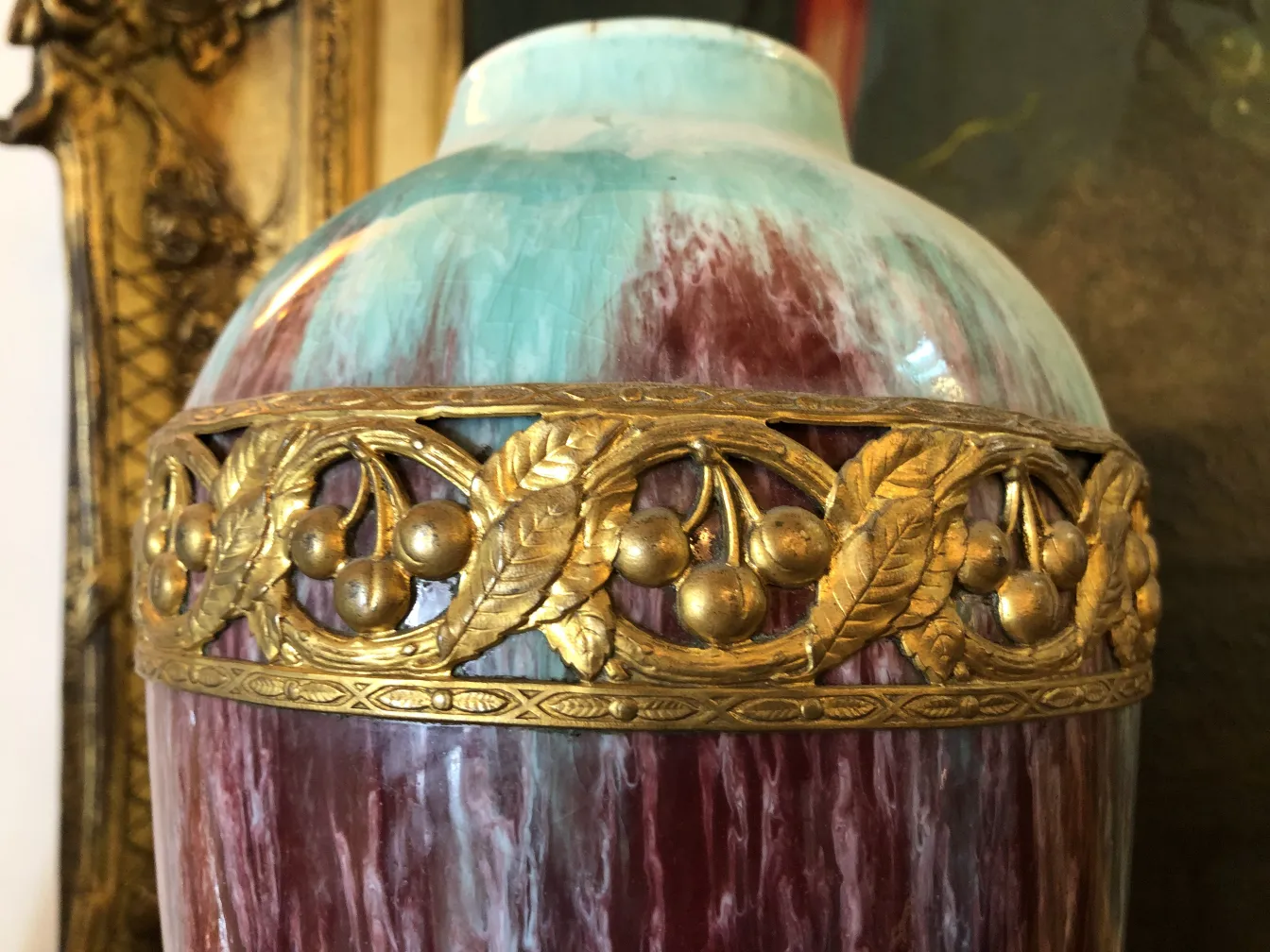 Antike Keramikvase mit blauen und roten Tönen, verziert mit erhabenen goldenen dekorativen Elementen.