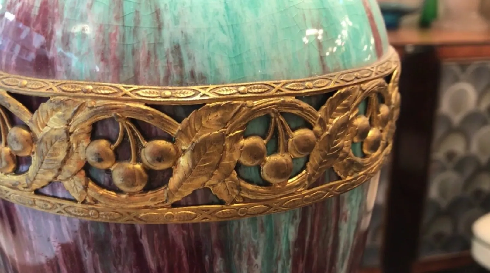 Céramique ancienne avec décoration dorée et fond coloré.