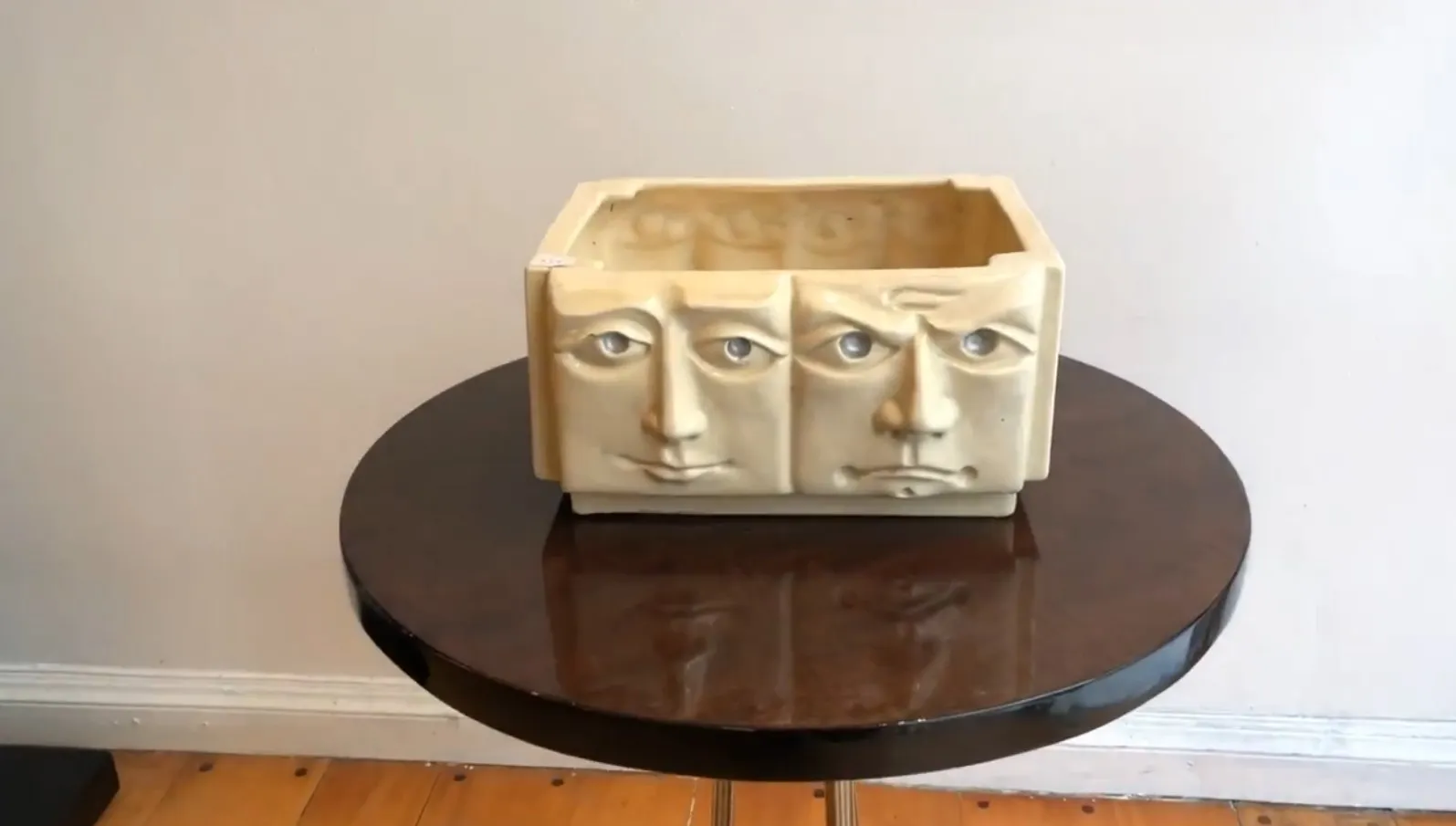 Céramique ancienne avec trois visages sur fond clair