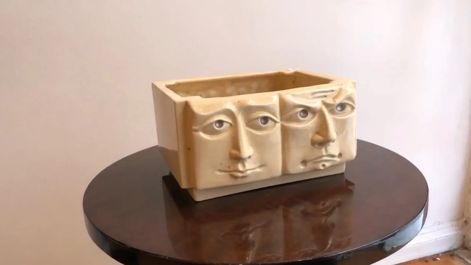 antique ceramic planter with sculpted faces in relief