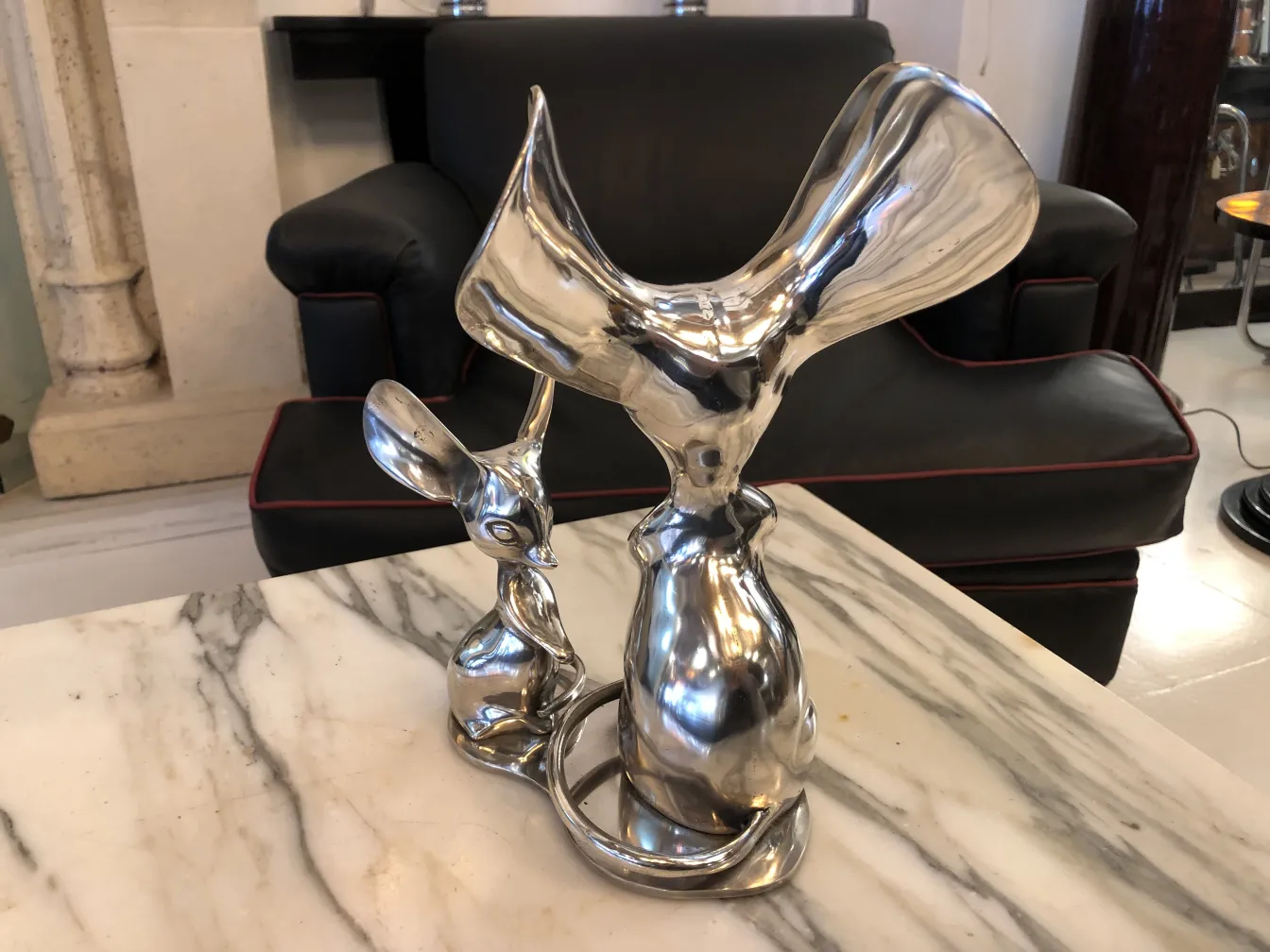 古代の金属彫刻で、カエルとウサギが大理石の上に描かれています