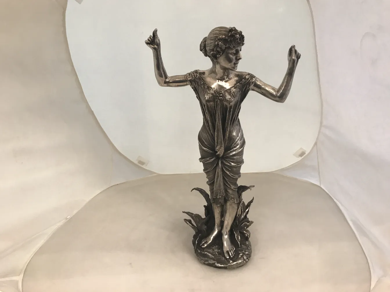 Escultura antiga de mulher em movimento com detalhes intrincados.